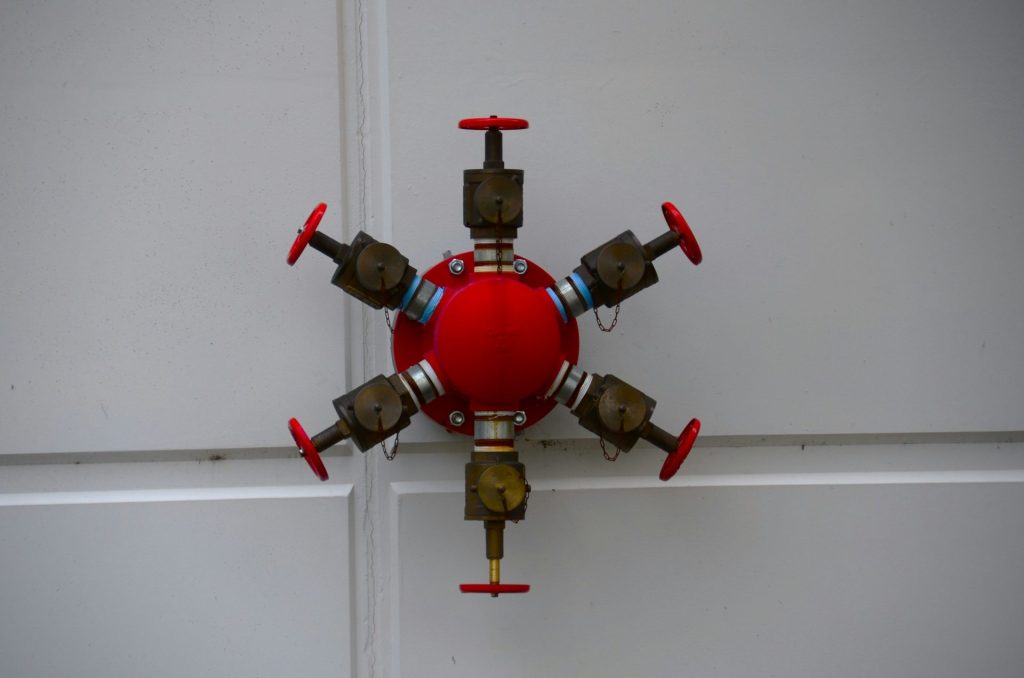 a red and gold clock on a white wall